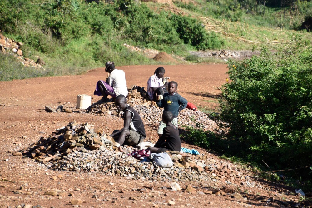 A few meters away some school dropouts work heavily ...